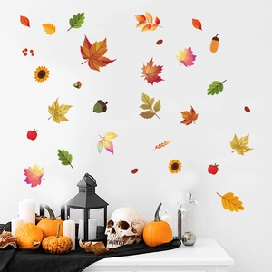 Detail view of Thanksgiving maple leaf and sunflower stickers on a clean white wall surface
