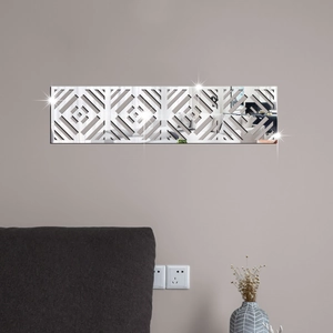 Detail of silver acrylic mirror wall sticker with geometric hollow patterns on gray wall