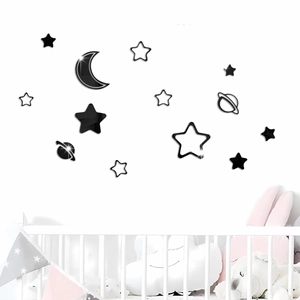 Detail view of black acrylic moon and stars wall stickers in a cozy nursery room setting