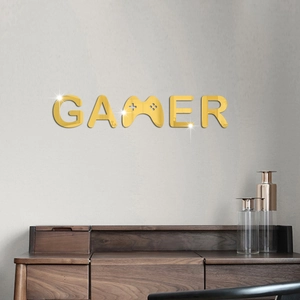 Detailed close-up of golden 3D acrylic mirror gamer wall sticker on a gray wall