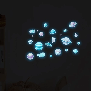 Luminous wall stickers showing planets and stars glowing in a dark room environment