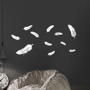 Detailed view of silver mirror feather wall stickers on a modern grey living room wall