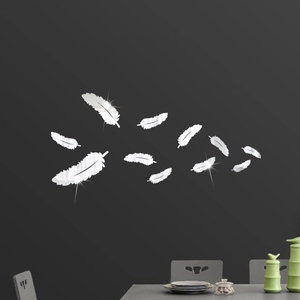 Detailed close-up of silver feather mirror wall stickers on dark living room wall