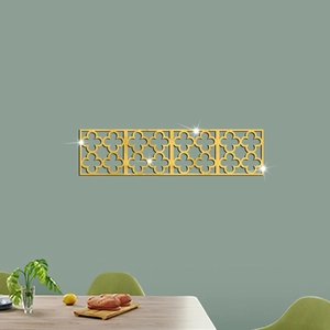 Detail of four gold geometric mirror wall stickers with clover hollow design on green wall
