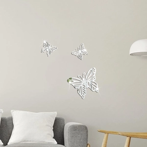 Drei hohle Schmetterlings-Spiegelaufkleber in Silber an einer modernen grauen Wohnzimmerwand