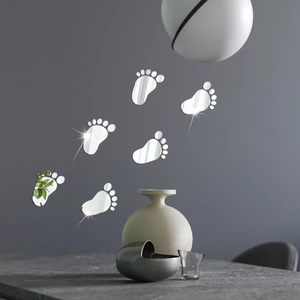 Macro view of silver mirror footprint acrylic wall stickers on a dark grey background