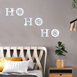 Close-up of silver mirror Ho Ho Ho snowflake wall decals on a modern bedroom wall