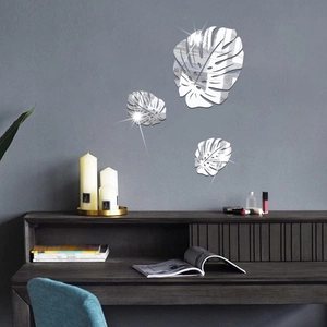 Three-piece set of silver monstera leaf acrylic mirror wall stickers on a grey wall