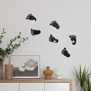 Detail of black acrylic footprint wall stickers with glossy mirror finish for modern decor