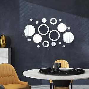 Silver acrylic mirror wall stickers with circular 3D reflective finish on a grey wall
