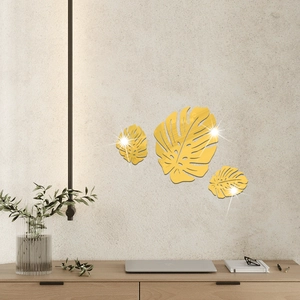 Three-piece golden mirror monstera leaf wall stickers in a modern minimalist living room