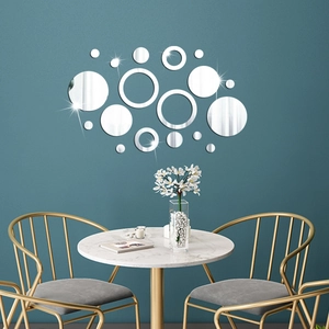 Detailed view of silver 3D acrylic mirror circle wall stickers on a dark teal dining room wall