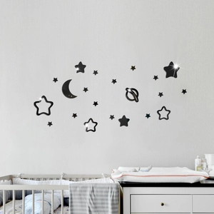 Detail of black acrylic mirror wall stickers with moon and stars in a cozy nursery setting