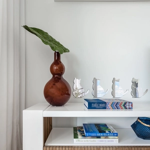 Detailed view of four modern acrylic cat mirror wall stickers on a minimalist white wall