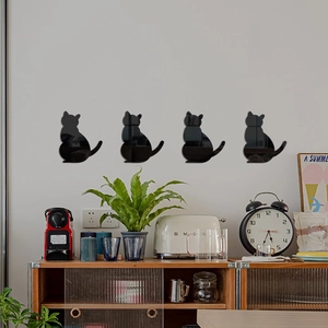 Detailed view of four black cat mirror wall decals arranged above a cozy wooden sideboard