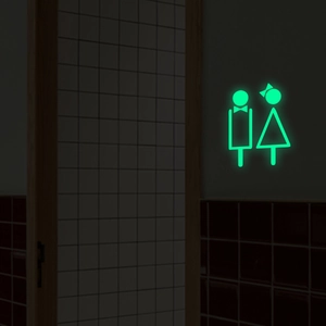 Sticker mural de toilettes lumineux vert montrant des icônes homme et femme sur carrelage
