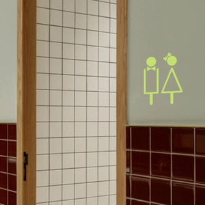 Signes de toilettes luminescents avec icônes créatives homme et femme sur le mur