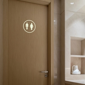 Glow-in-the-dark bathroom door decal featuring male and female icons on wood surface