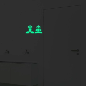 Luminous king and queen crown stickers glowing green on bathroom doors in dark rooms