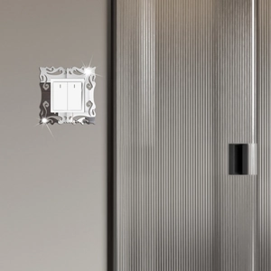 Macro detail of silver acrylic mirror switch panel with elegant floral cutout design