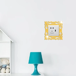 Golden mirror acrylic switch frame with ornate vintage floral carving on a white wall