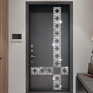 Détail des stickers muraux géométriques en acrylique argenté sur une surface de porte gris foncé