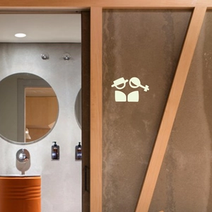 Leuchtende Badezimmeraufkleber mit minimalistischen Symbolen auf einer Holztür in Industrieoptik