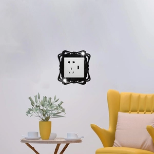 Detail of a black ornate acrylic switch frame on a white wall socket in a modern room