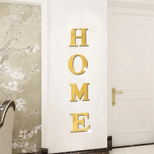 Close-up of golden 3D acrylic HOME mirror wall stickers with reflective metallic finish