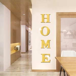 Detailed close-up of 3D mirror gold HOME wall stickers on a modern hallway wall