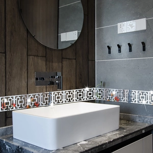 Detail showing modern geometric mirror wall stickers with red floral accents in a bathroom