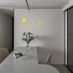 Detail view of yellow mirror acrylic wall stickers with sun moon and stars on white wall