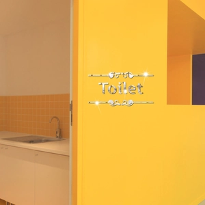 Adesivo murale specchio argento per toilette con eleganti motivi a ricciolo su muro giallo