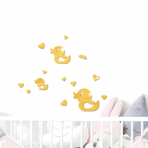 Detailed view of golden mirror duck and heart acrylic wall stickers in a cozy nursery