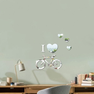 Macro detail of 3D bicycle and heart mirror wall stickers on a green indoor wall