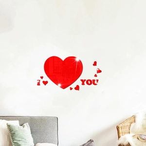 Close-up of bright red acrylic heart mirror wall stickers and I LOVE YOU text on white wall