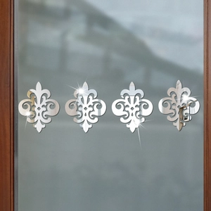 Detailed view of silver acrylic fleur-de-lis mirror wall stickers on a wooden door