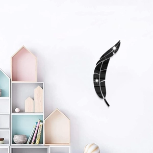 Detail of black acrylic feather wall sticker with a reflective mirror finish on white wall