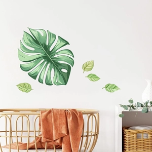 Détail de stickers muraux feuilles de monstera dans une chambre de bébé