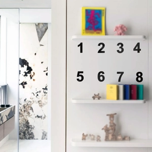 Minimalist black acrylic number 1 to 8 wall stickers on white wall for home decor