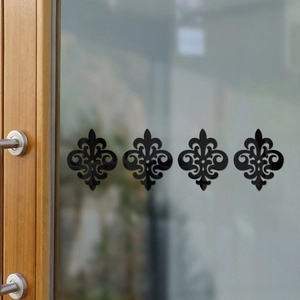 Detailed view of four black fleur-de-lis acrylic wall decals on a frosted glass door