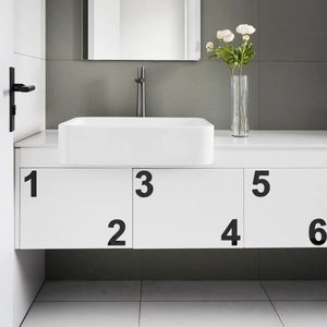 Detail of modern white ceramic rectangular washbasin on cabinet with black faucet