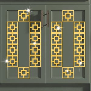 Detailed view of gold acrylic geometric mirror stickers on dark green furniture doors