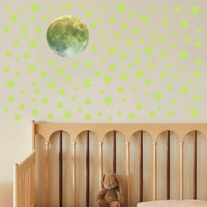 Luminous wall stickers set with moon and stars above a baby crib in a cozy nursery