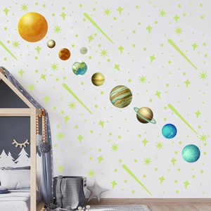 Adesivi murali sistema solare con stelle luminose su muro bianco sopra un letto in legno