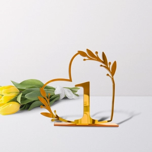 Golden acrylic heart-shaped wedding table number with elegant leaf patterns and base
