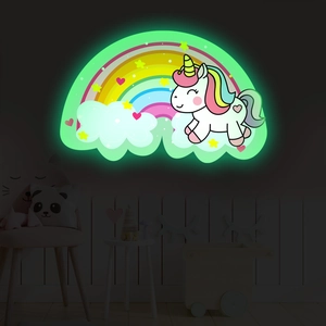 Glow-in-the-dark unicorn and rainbow wall sticker in a cozy kids bedroom setting