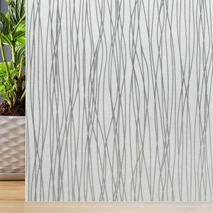 Detail of frosted glass privacy film featuring modern grey wavy lines and matte texture