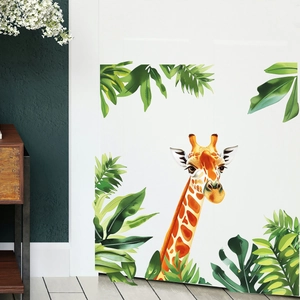 Macro view of tropical leaves and hand-drawn giraffe wall sticker on a white door surface