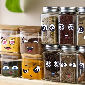 Detail of square glass spice jars with bamboo and metal lids on a wooden shelf